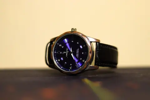 A wristwatch with a dark dial and a leather strap